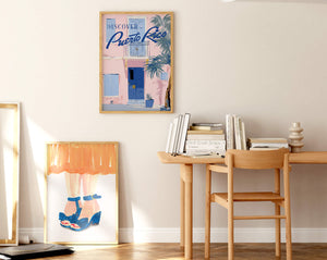 En stue med plakat på væg og en plakat der står på gulvet. Nordisk hjem med farverig indretning.